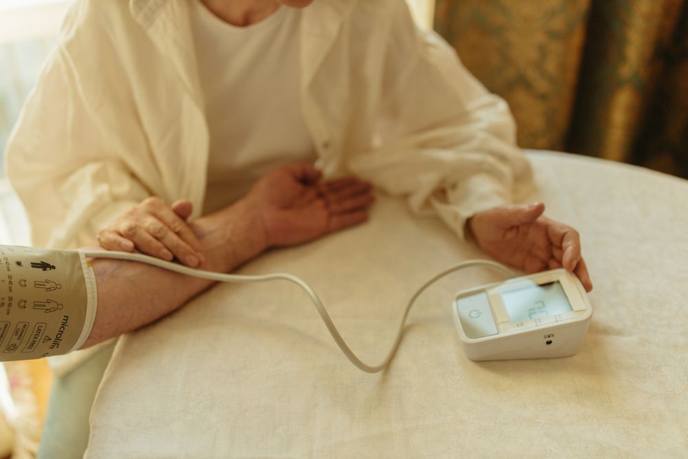Older adult using a blood pressure monitor. Illustrative stock photograph